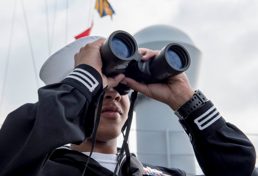 Operations Specialist 2nd Class Brandon Castillo looks through binoculars aboard the Blue Ridge-class command and control ship USS Mount Whitney (LCC 20) as the ship returns from its support in exercise Baltic Operations (BALTOPS) 2019.