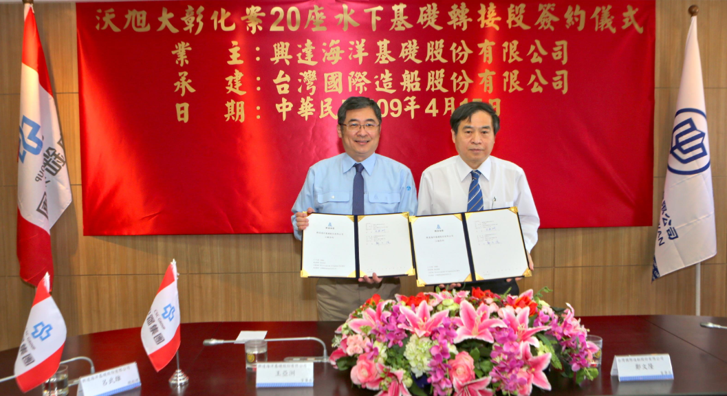 A photo of CSBC and SDMS officials at the contract signing, with a celebratory banner in background