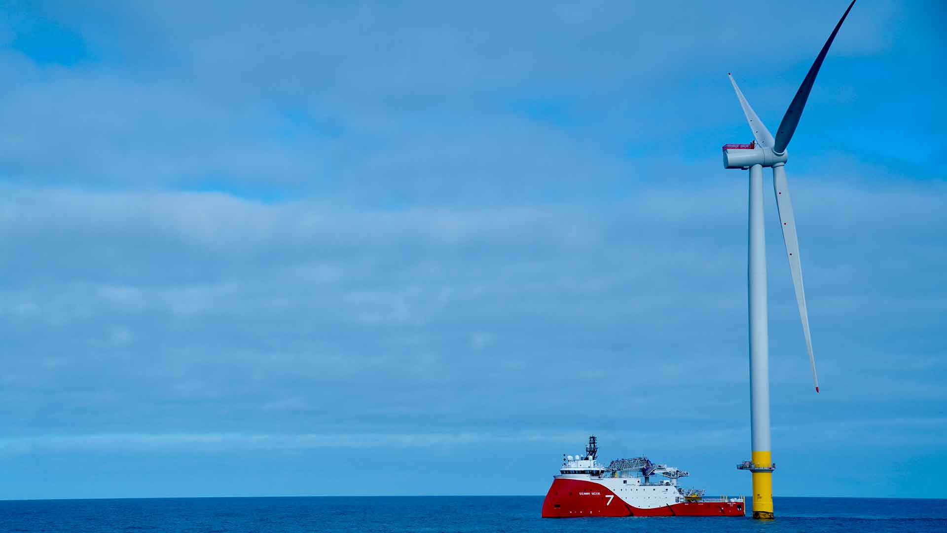 A photo of Subsea 7's vessel next to a wind turbine at sea