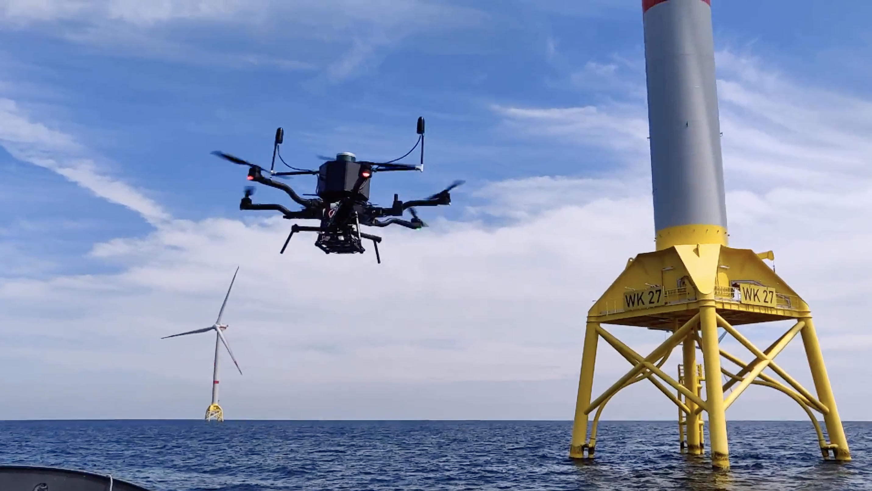 A blade inspection drone near one of the turbines