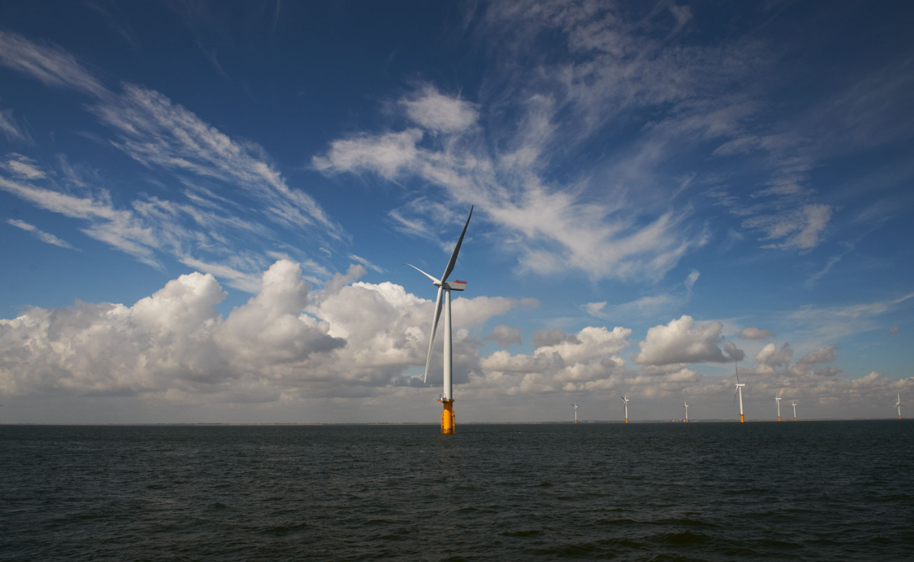 A photo of an offshore wind farm with one turbine prominently seen