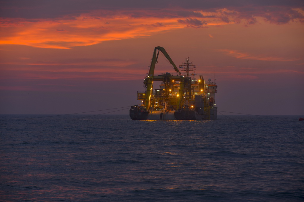 A cable laying vessel working at sea in dusk