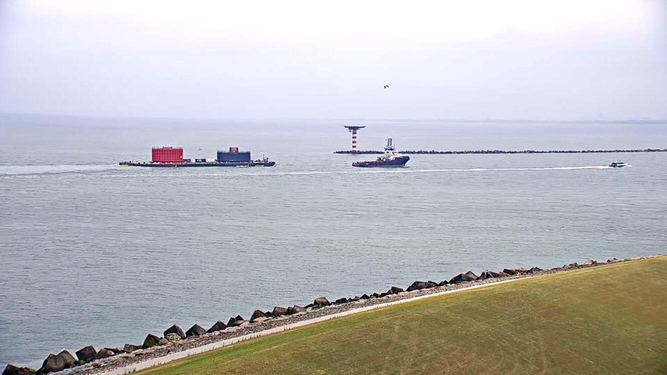 A photo of the tug and barge carrying HKZ Alpha cables taken from shore