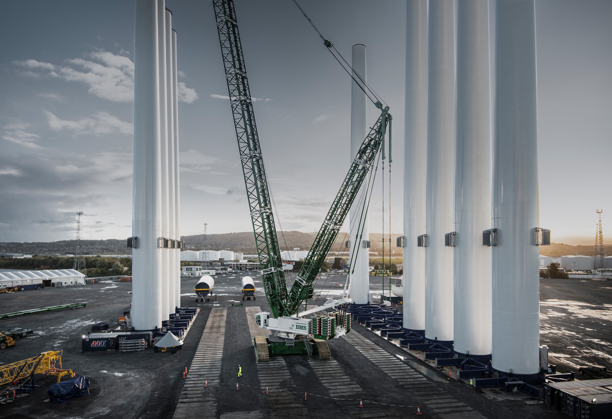 A photo of wind turbine towers lined up at a manufacturing site