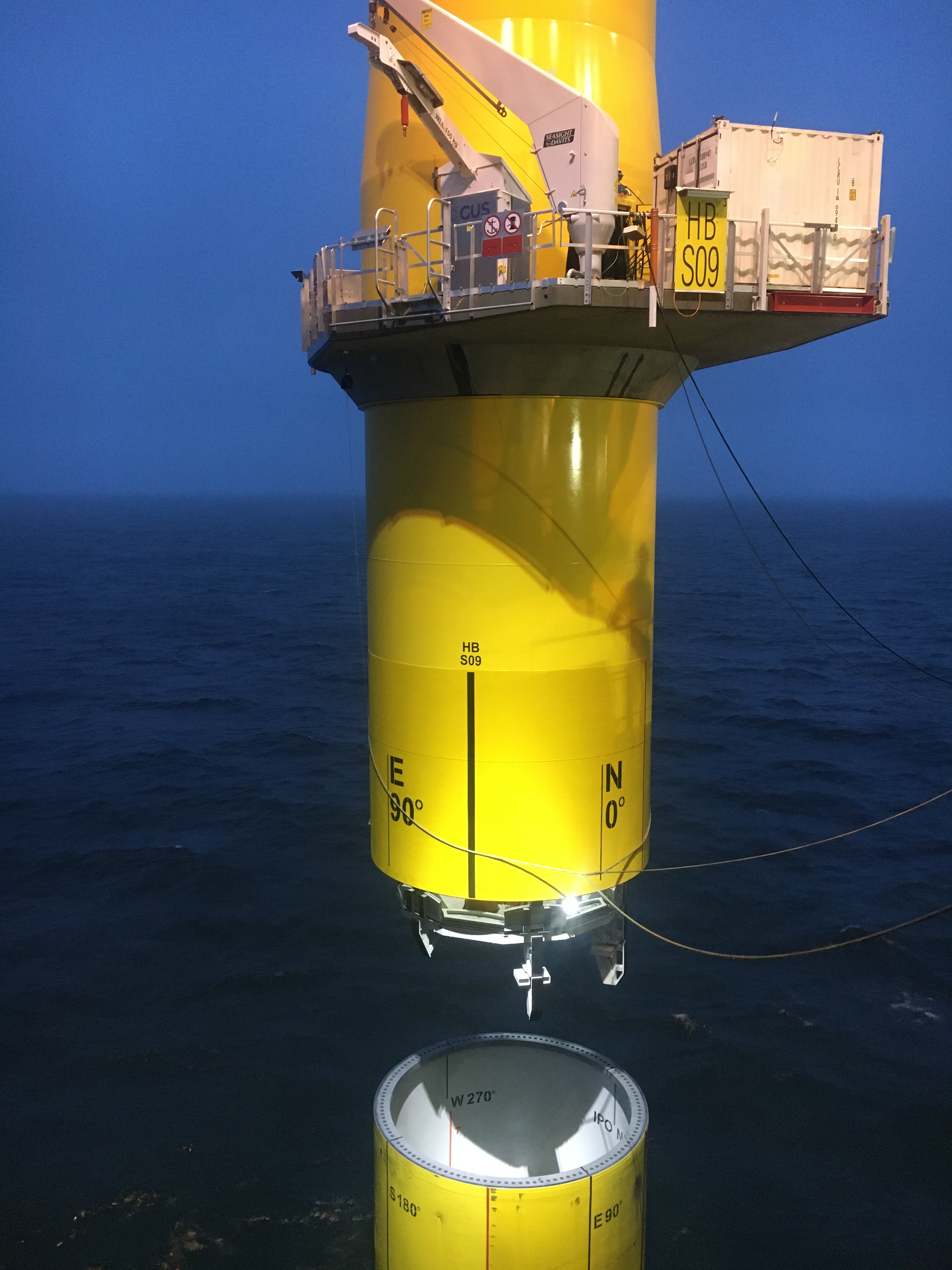 Yellow transition piece being lowered onto the monopile at the Hornsea Two site off the UK