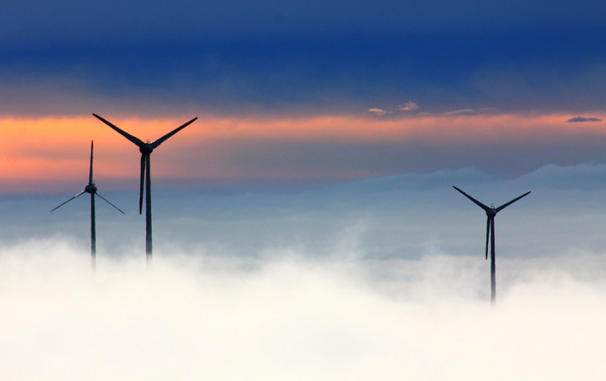 Wind turbines reaching above clouds