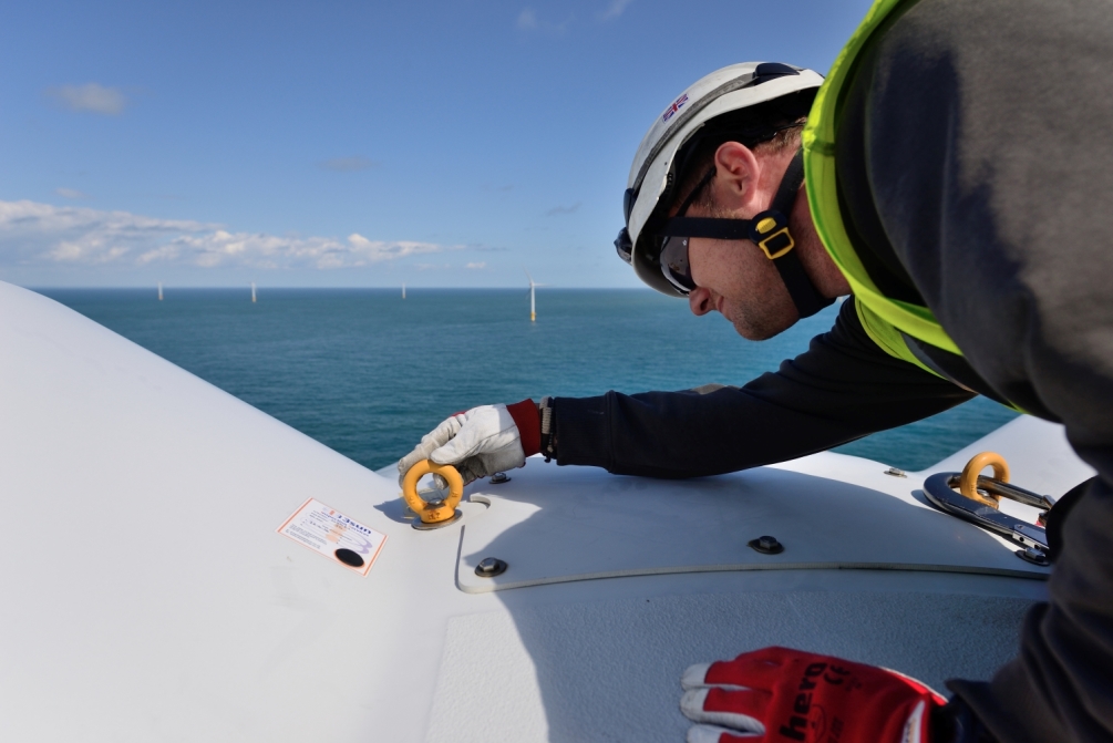 A technician on top of an offshore wind turbine