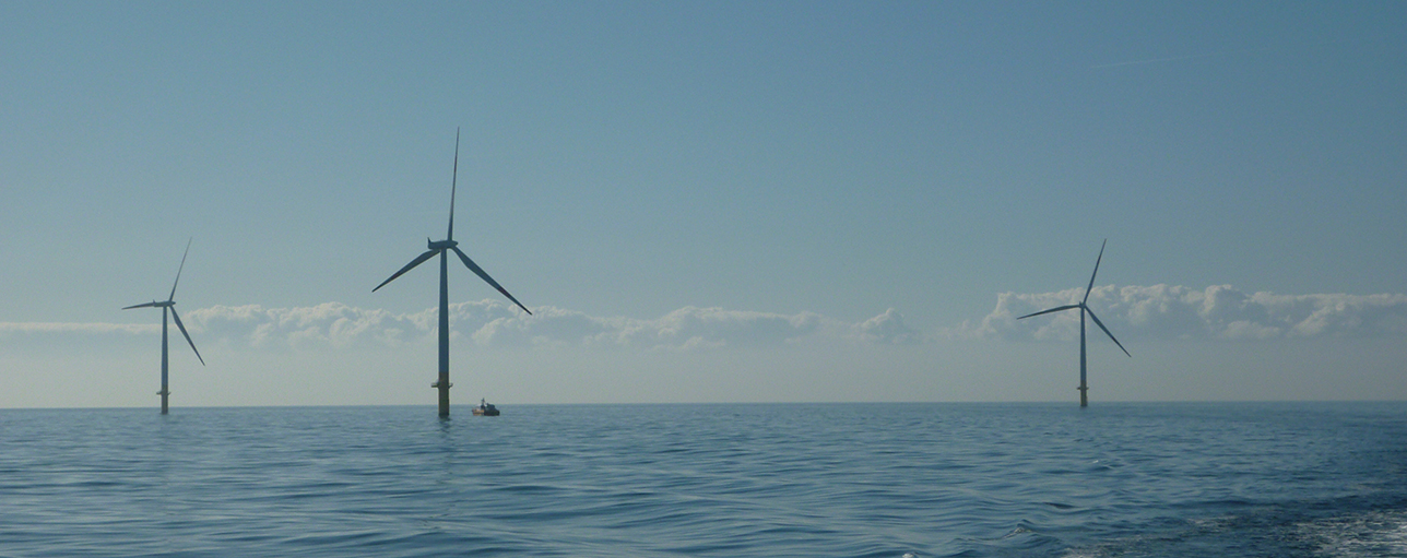 A photo of an offshore wind farm with a crew transfer vessel at the site