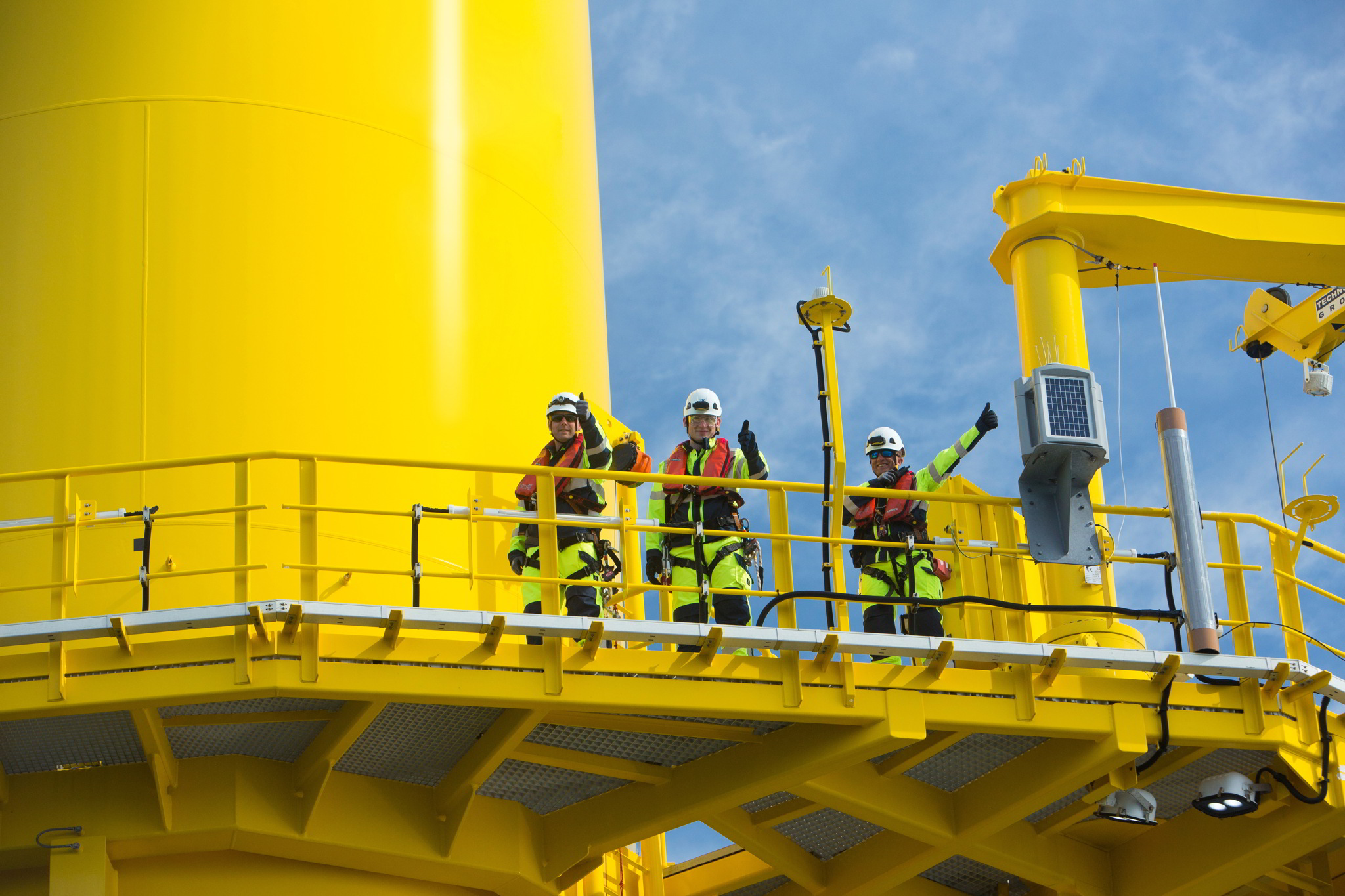 A photo of the Deutsche Windtechnik team on an offshore wind turbine platform at the Nordergrunde offshore wind farm