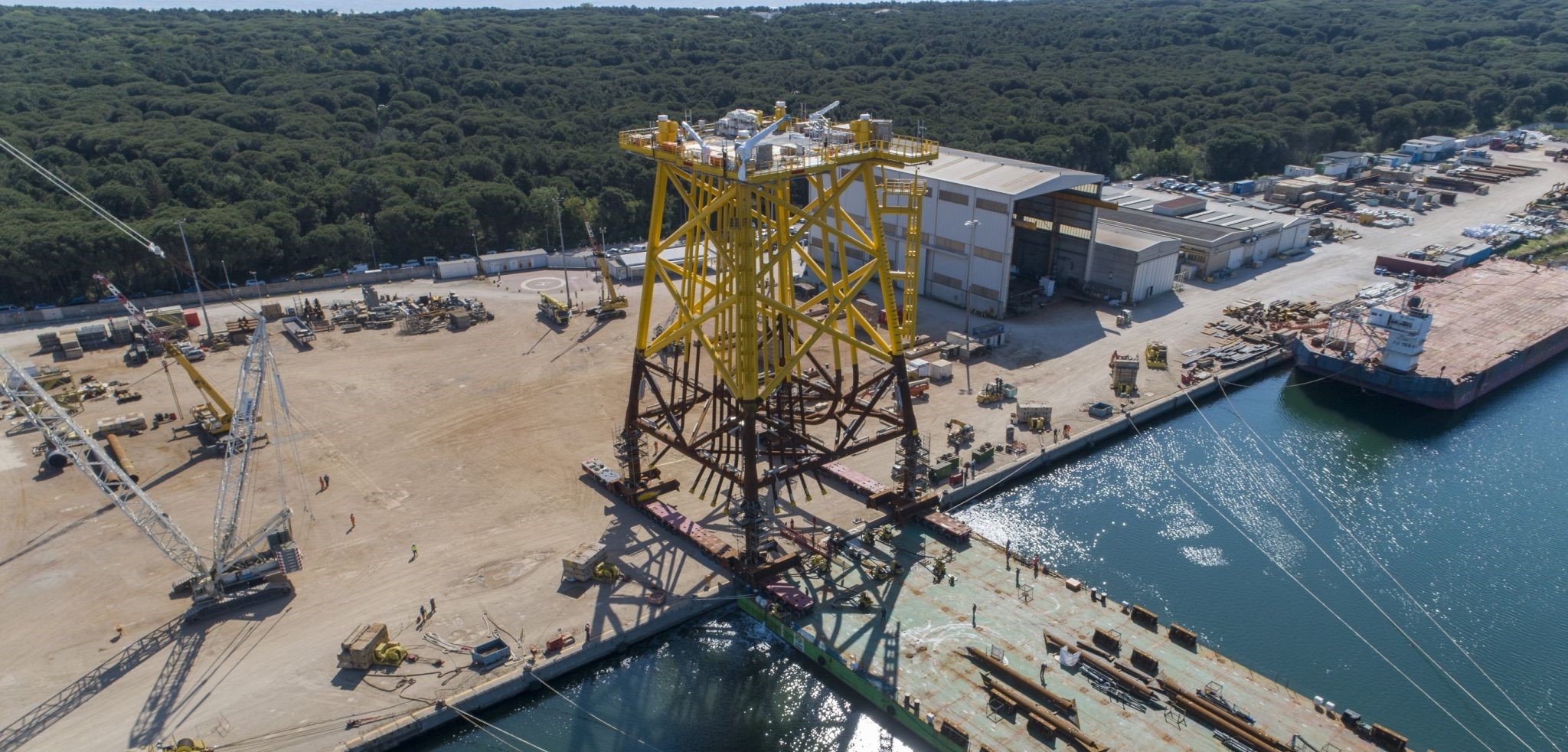 An aerial photo of the Saint-Nazaire substation jacket being loaded onto a barge at Rosetti Marino yard in Italy