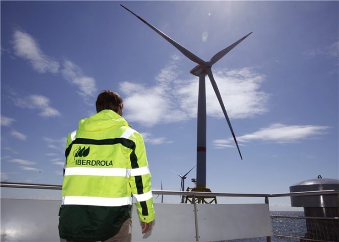A photo of an Iberdrola worker facing an offshore wind farm