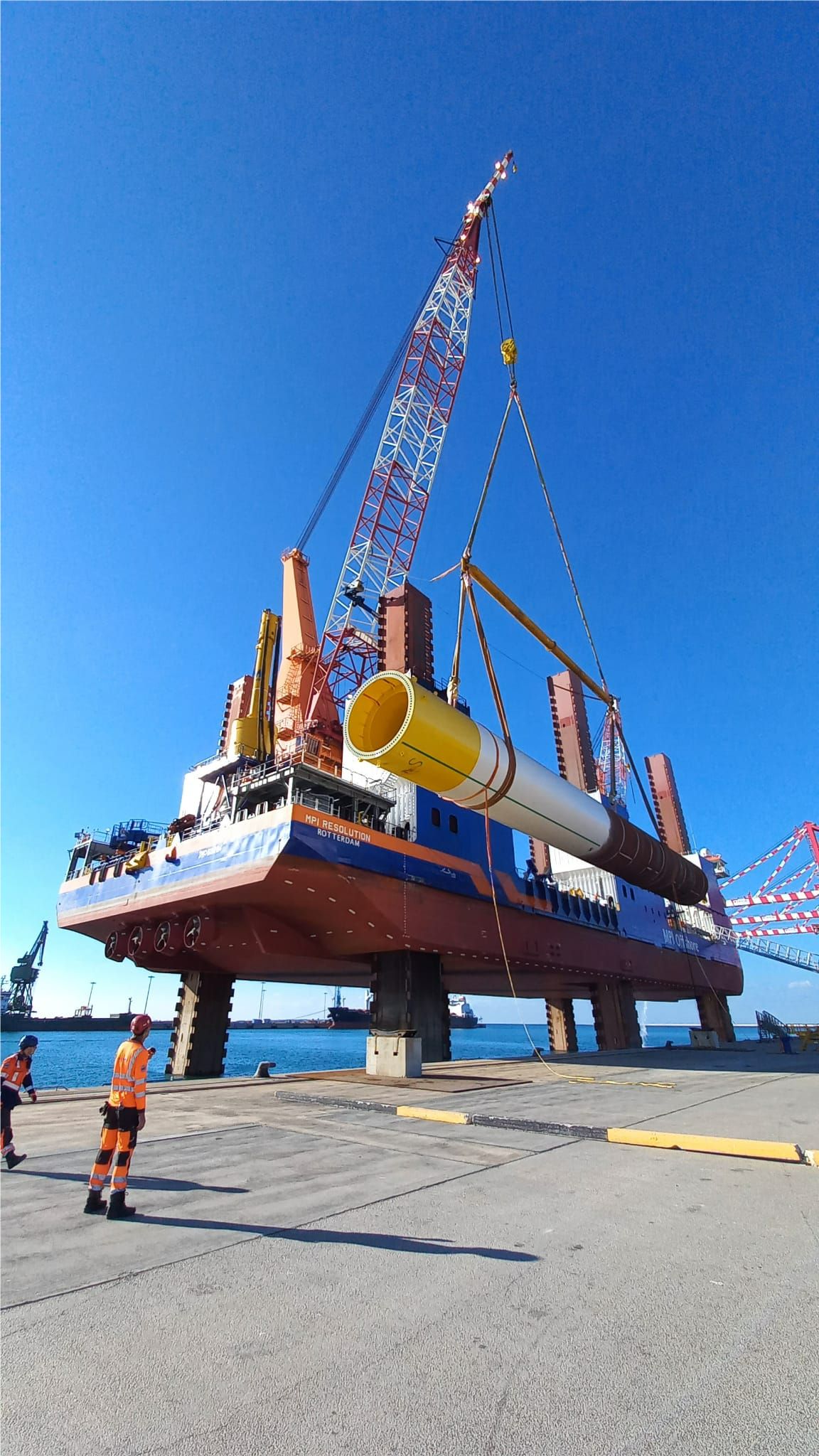 A photo of the MPI Resolution vessel loading a monopile for the Taranto offshore wind farm in Italy