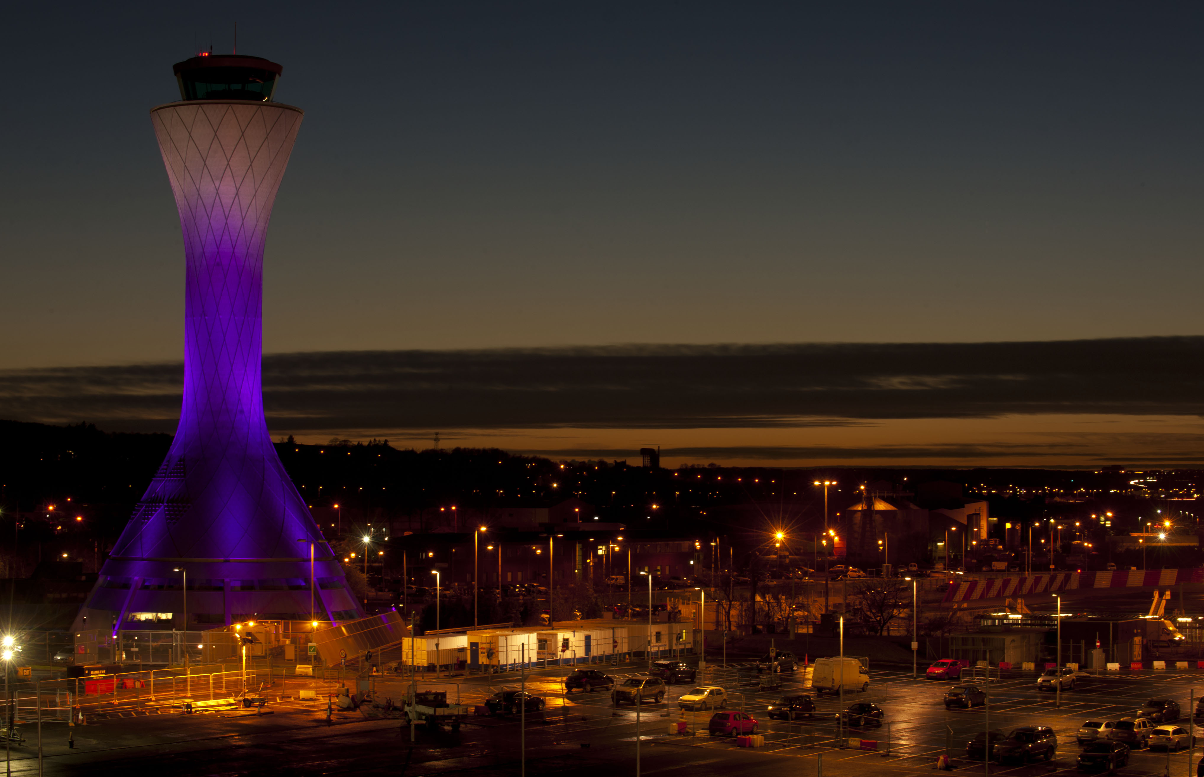 A night photo of the Edinburgh Airport's tower in pink to mark ownership change