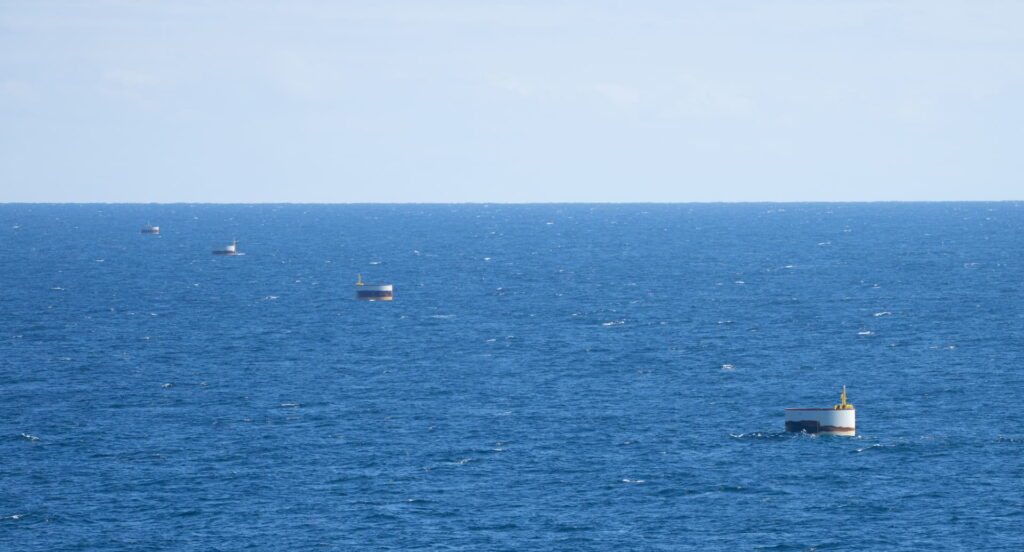 A photo of monopiles protruding through water surface at Coastal Virginia Offshore Wind (CVOW) site