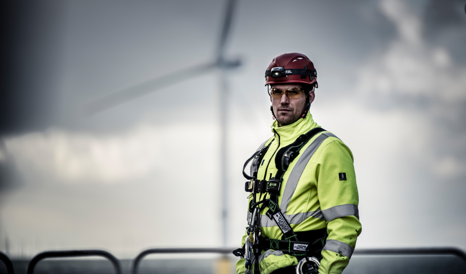 A MHI Vestas photo, offshore wind technician with wind turbine blurred in the background