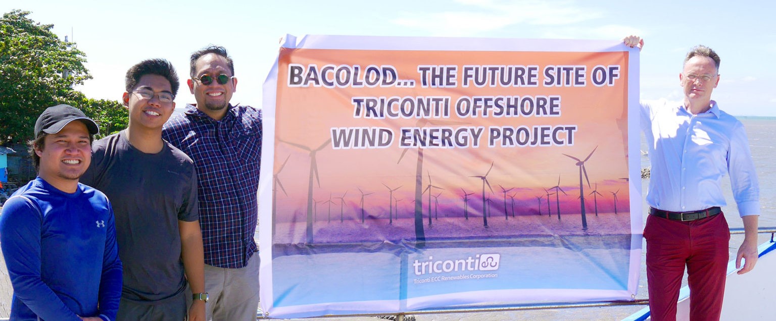 Team from Triconti Windkraft Group holding a company banner