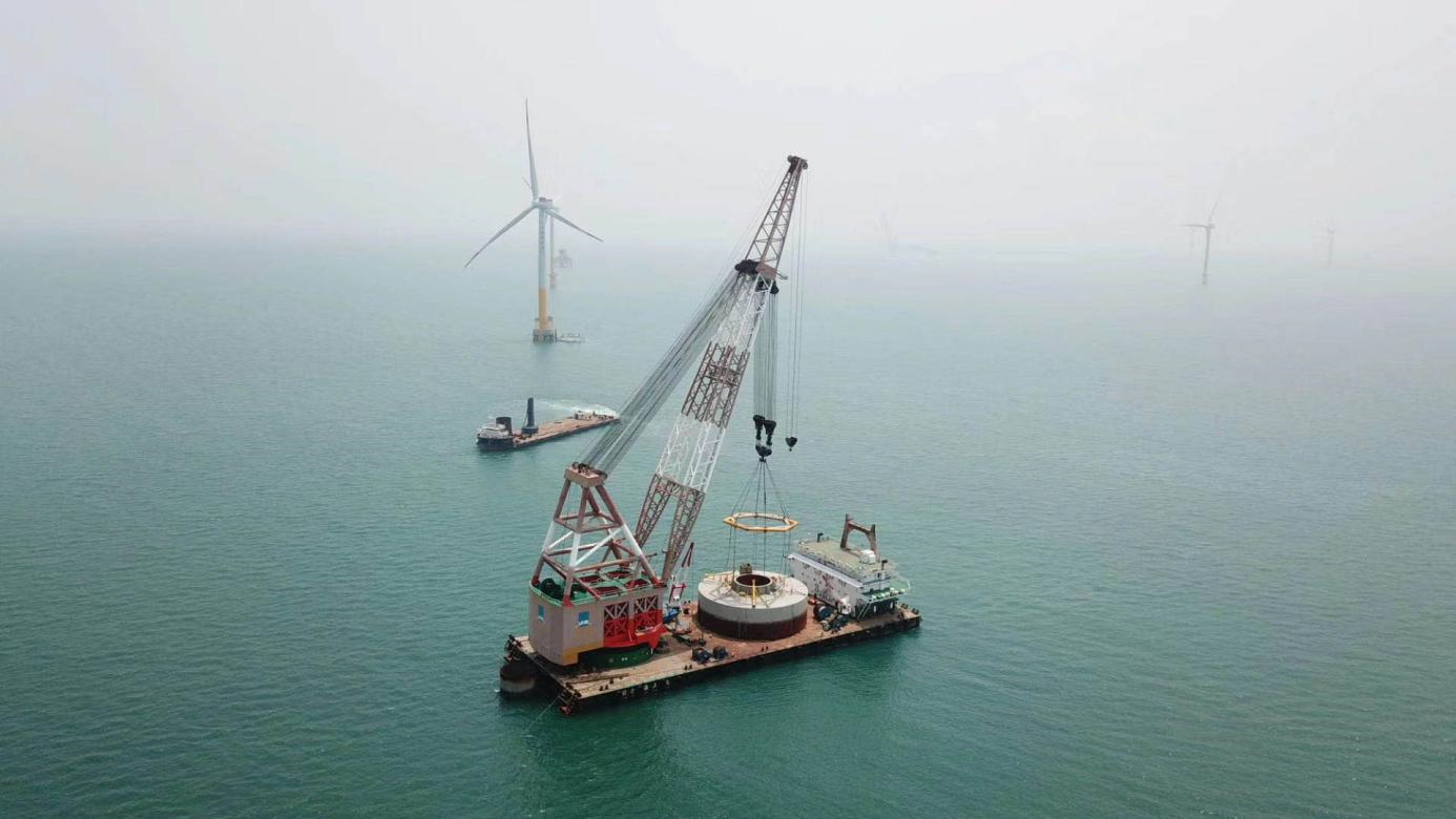 A photo of the monopile-caisson foundation being installed at the offshore wind project site