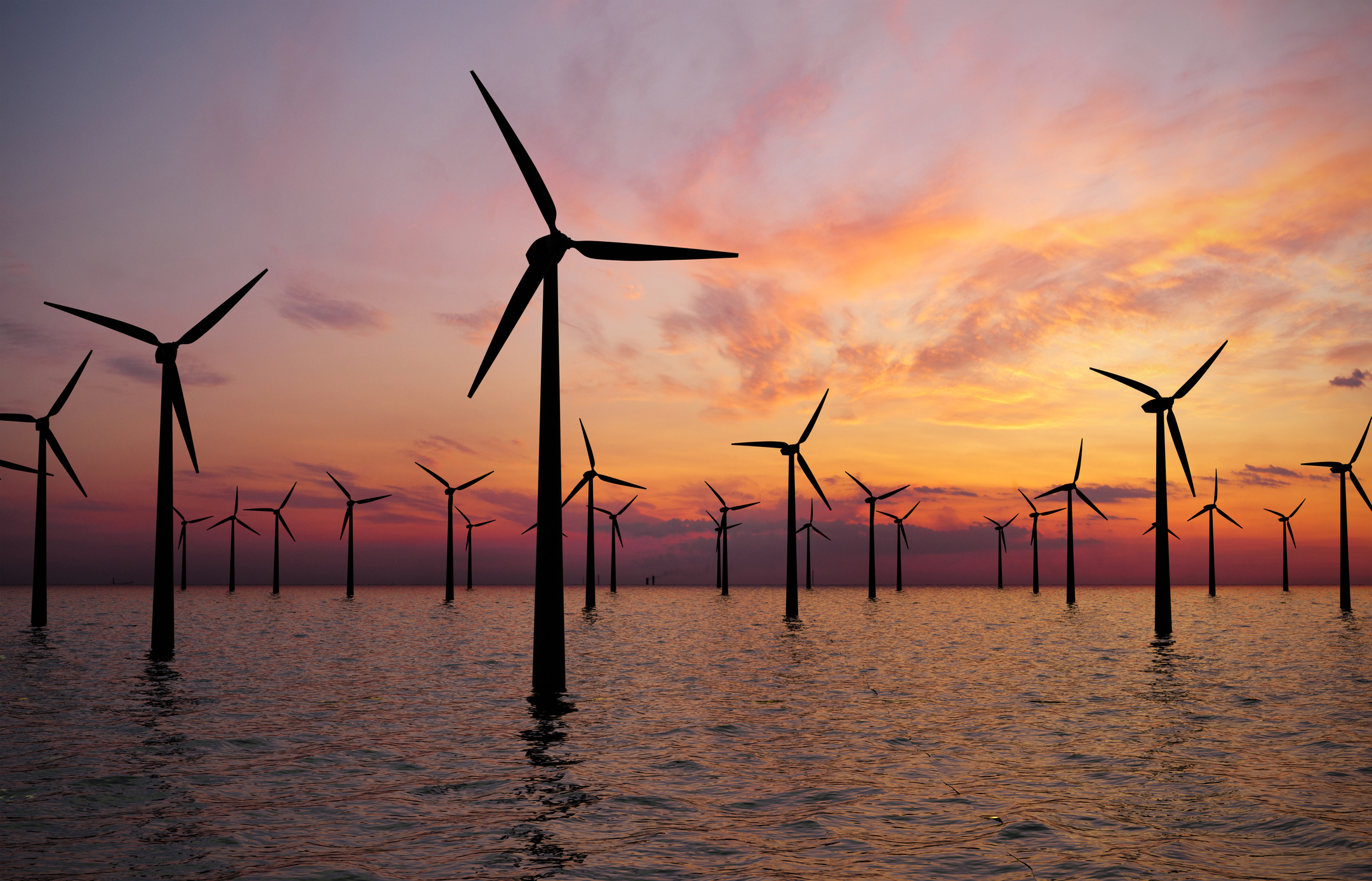 Offshore wind turbines in sunset, illustrative image