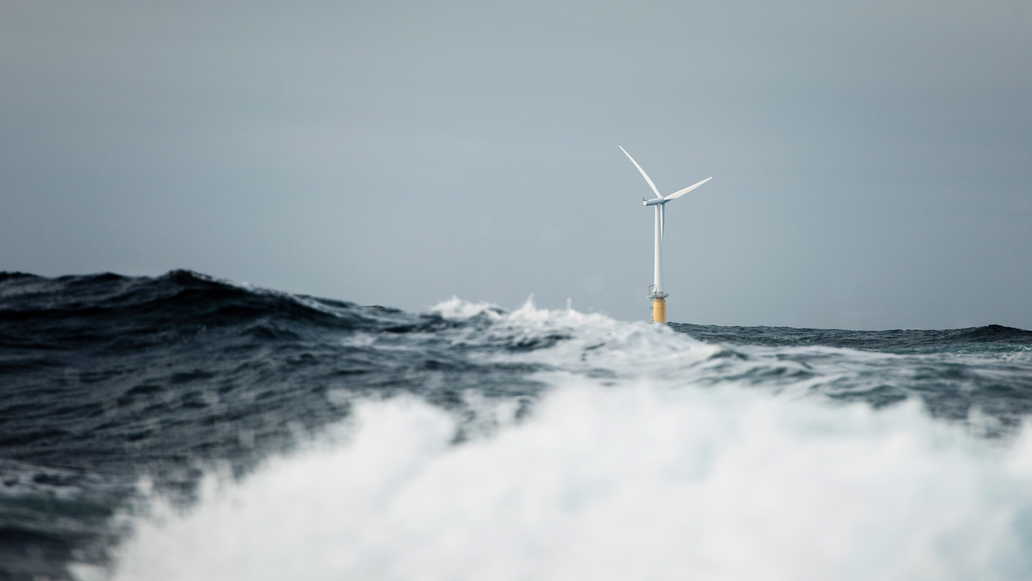 A floating wind turbine out at sea photographed from sea surface level