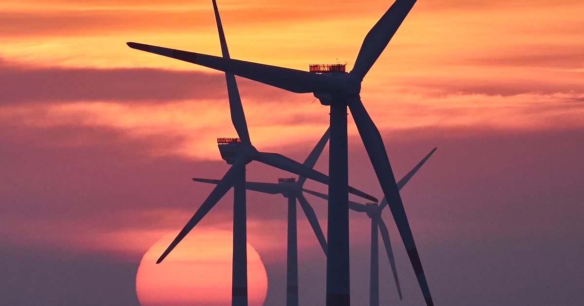 A photo of offshore wind turbines in sunset