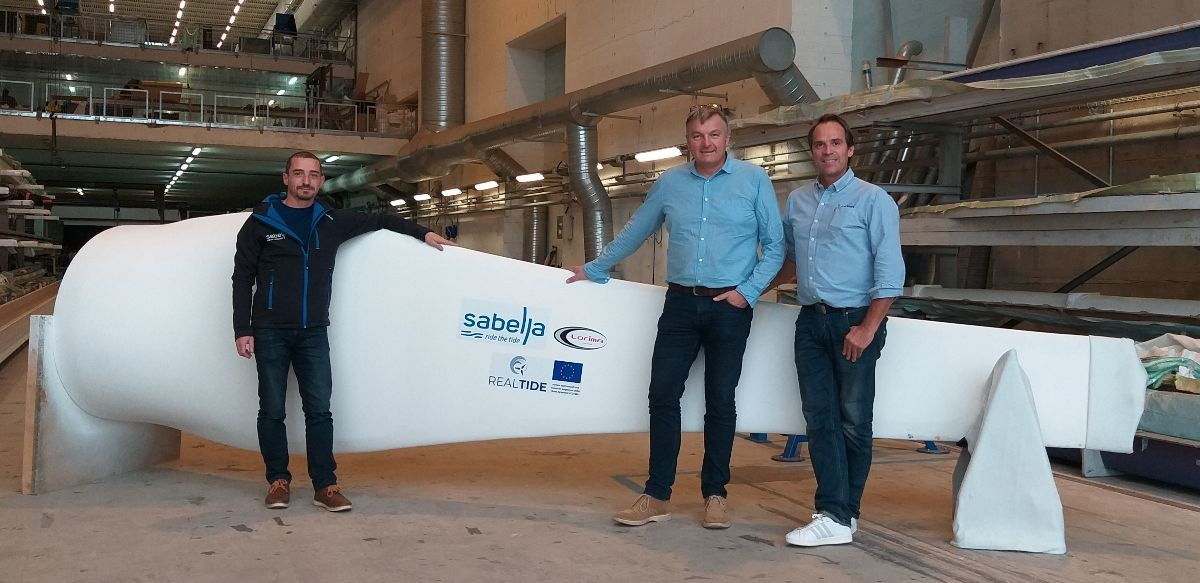 A photo of Erwann Nicolas, Fanch Le Bris, and Vincent Marsaudon beside the blade prototype (Courtesy of Sabella)