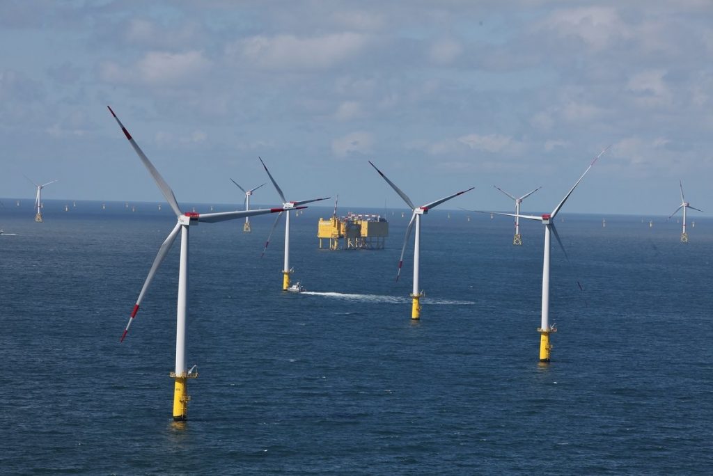 An offshore wind farm with TenneT offshore grid platforms in the background