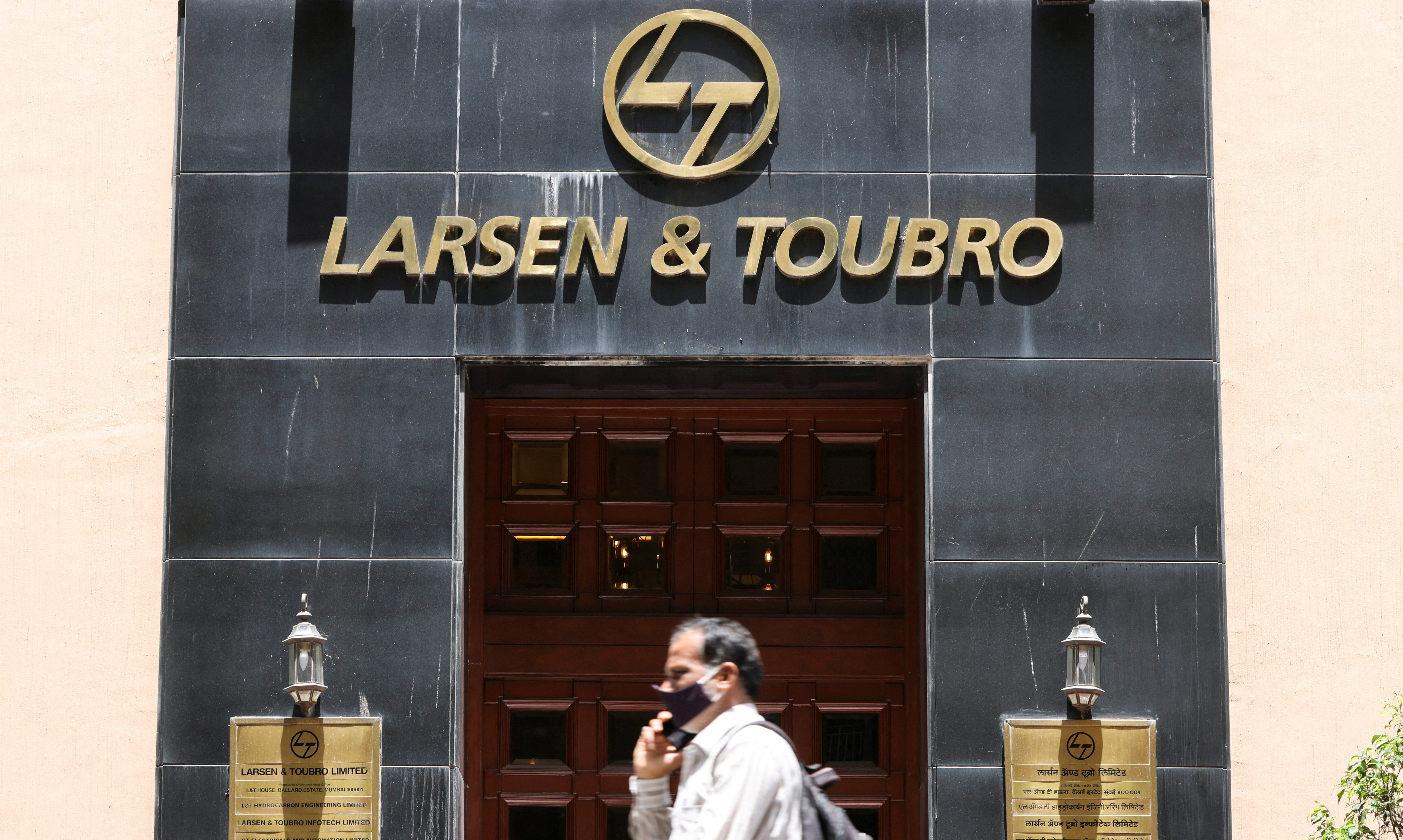 FILE PHOTO: A man walks past the Larsen and Toubro (L&T) head office in Mumbai, India, September 2, 2021.