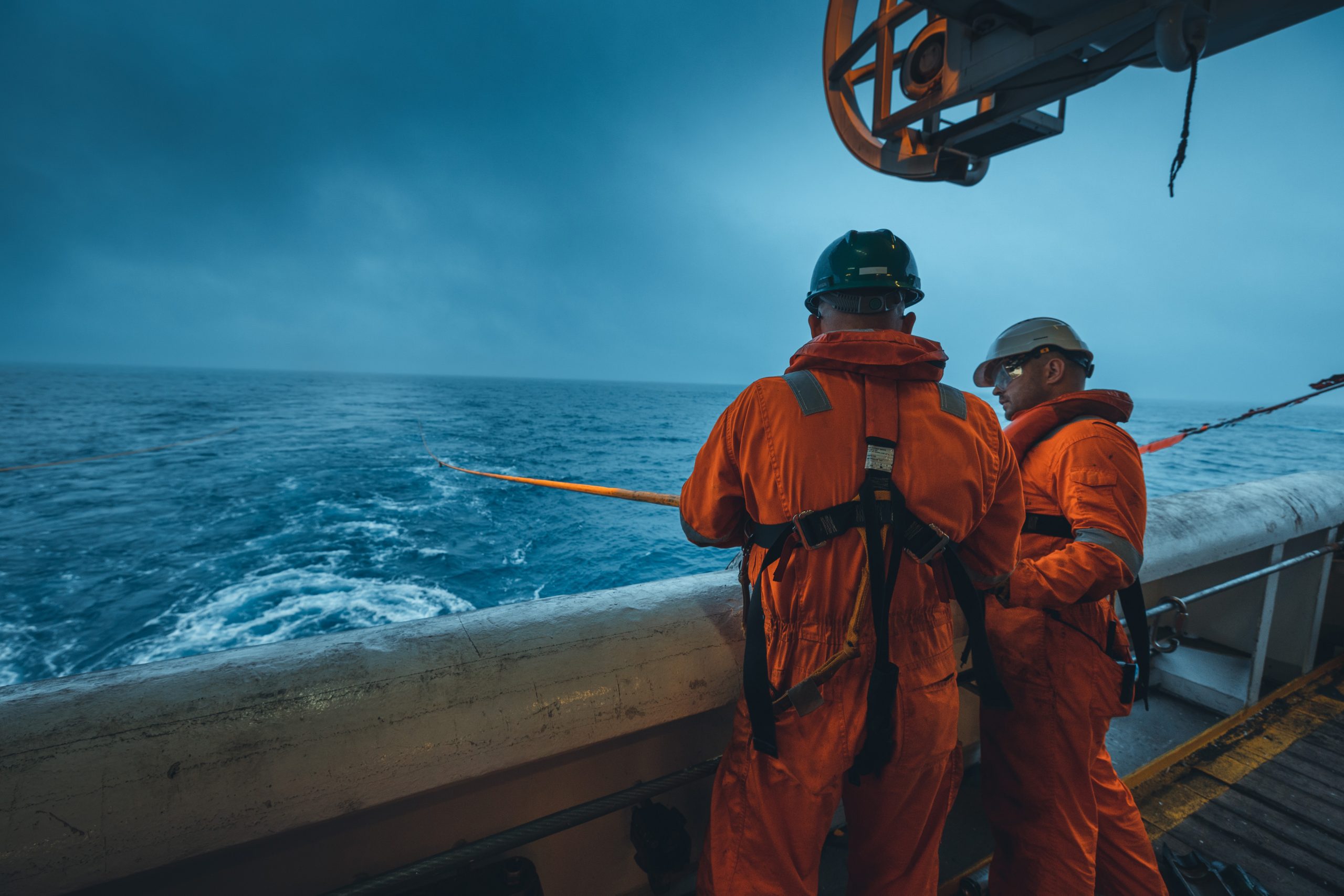 Shearwater employees in orange suits doing offshore projects.