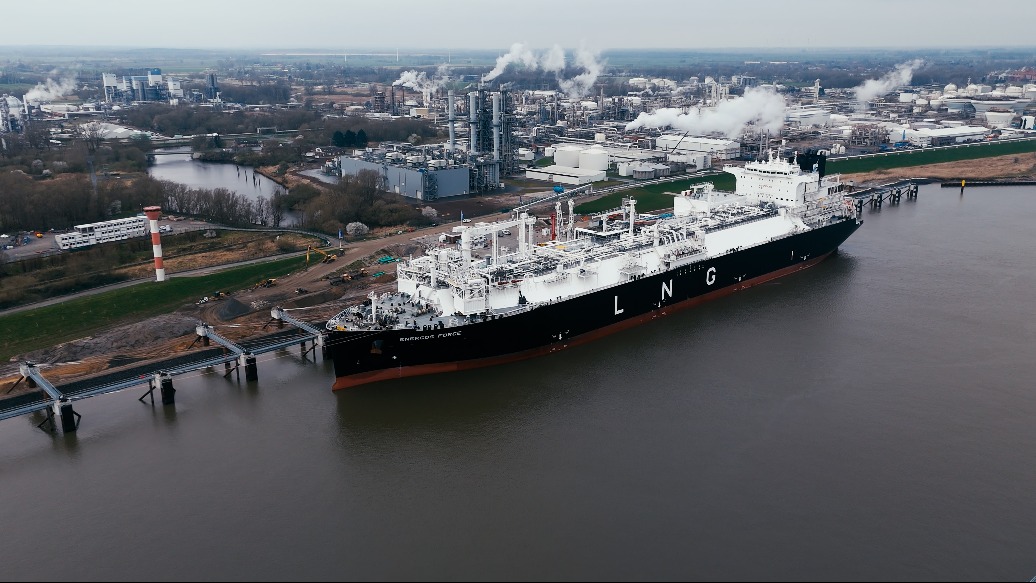 Vessel anchored at a port next to an industrial complex onshore