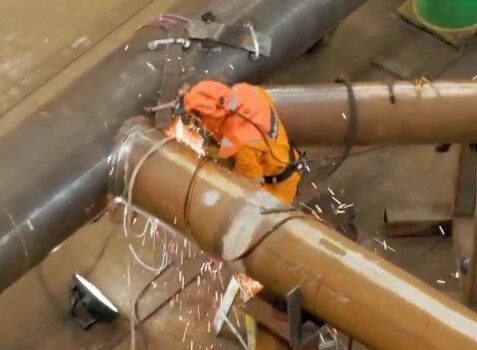 Worker welding a pipe