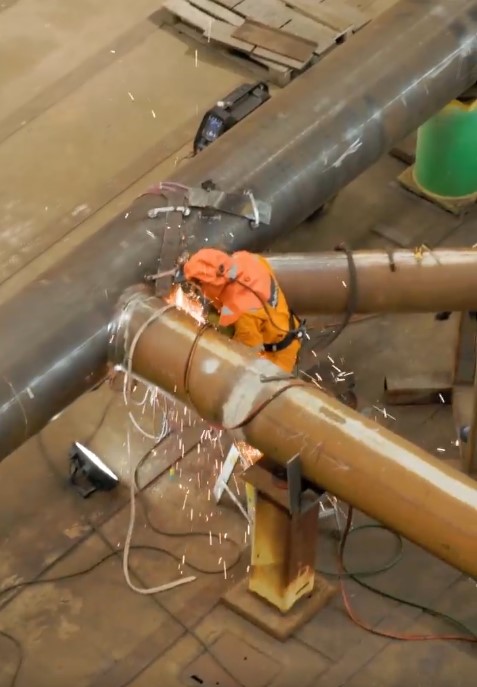 Worker welding a pipe