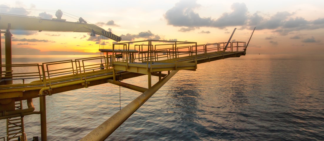 A view of a bridge on an offshore platform at sunset