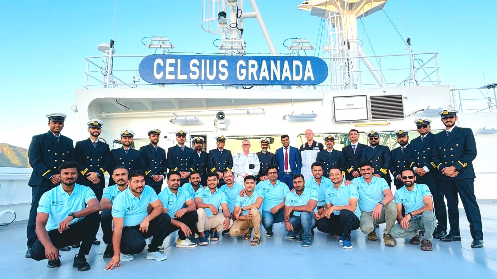 20+ people standing in two lines on a boat's deck