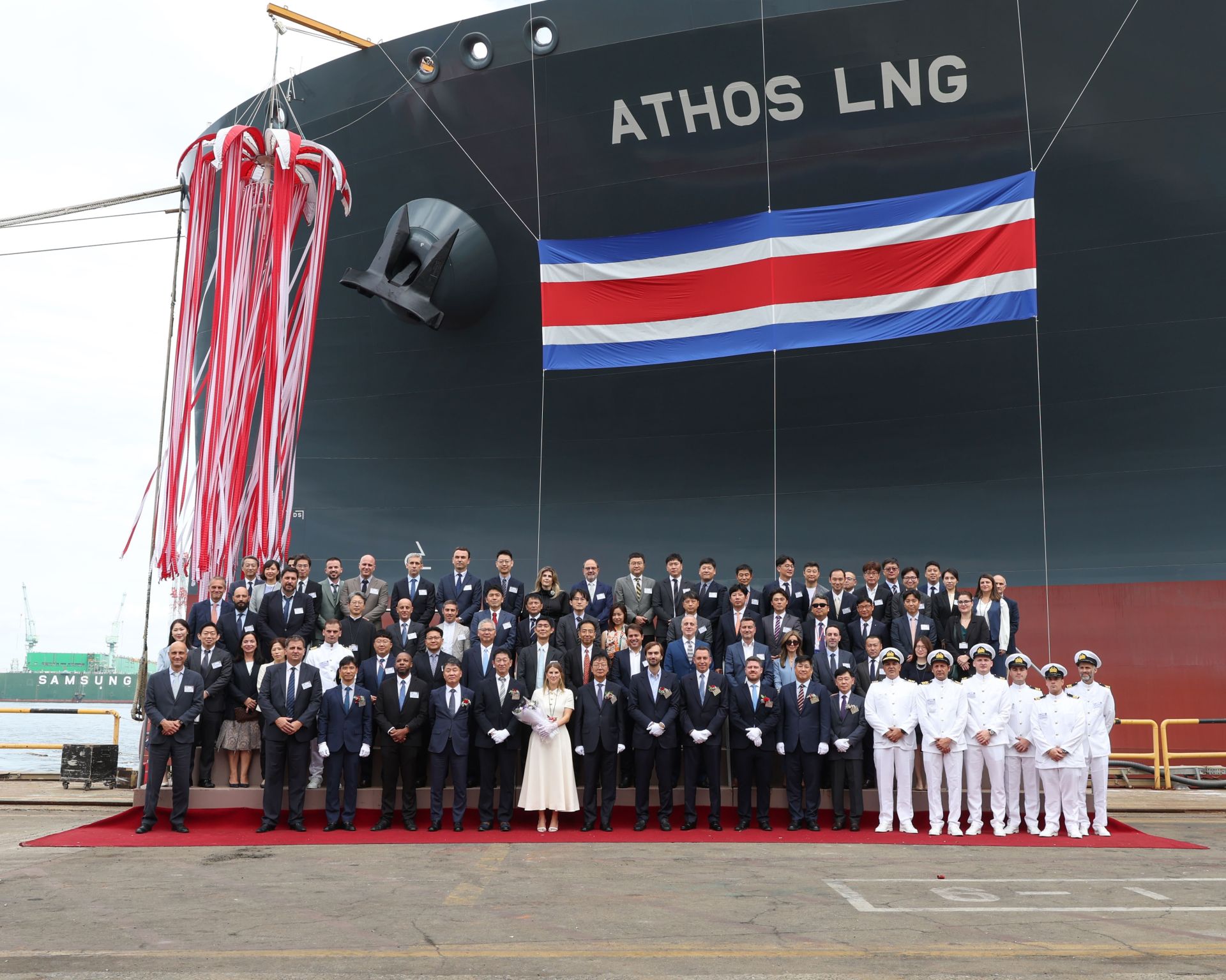 A large group of people standing in front of a vessel