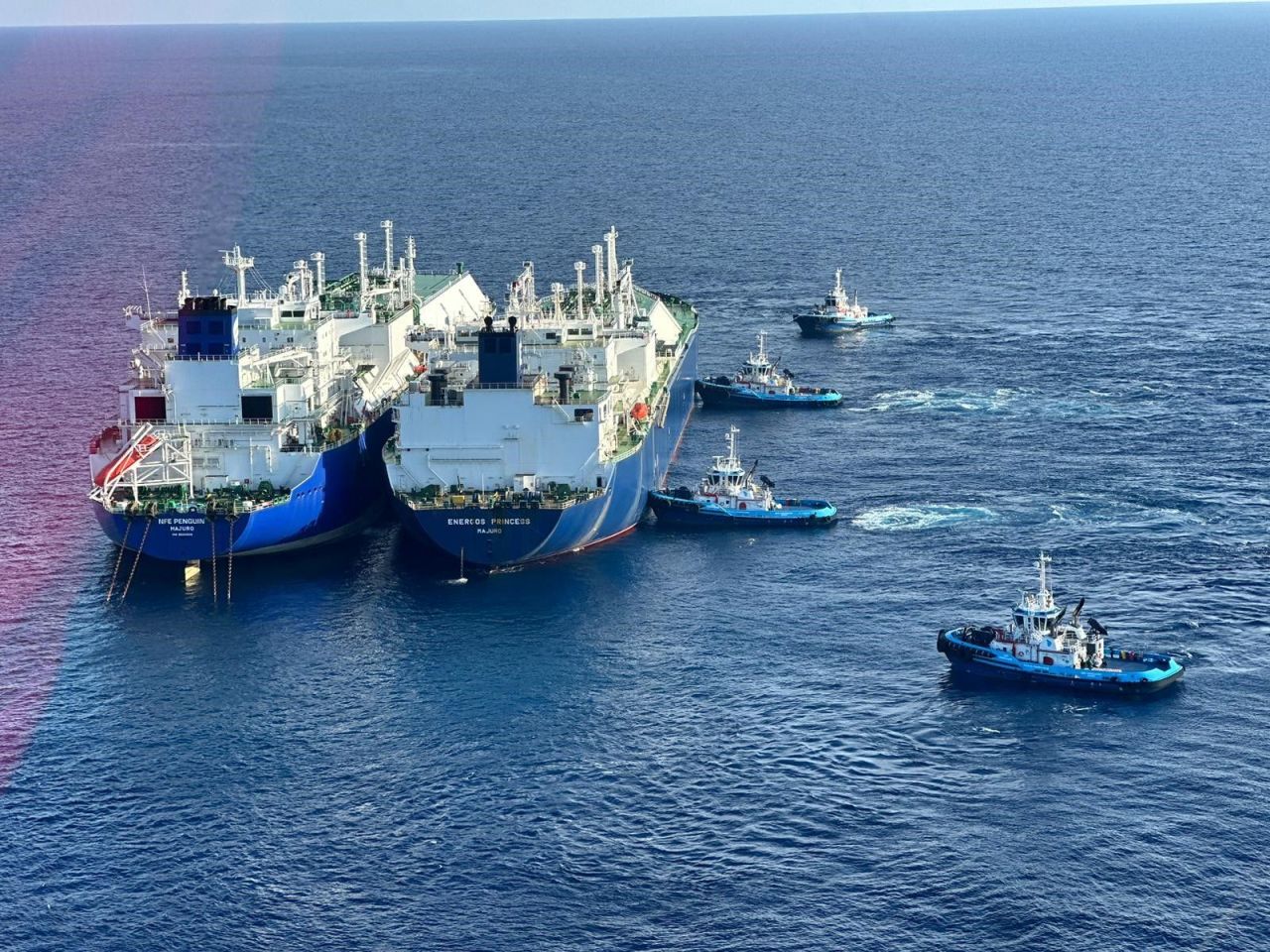 Two large vessels at sea surrounded by four smaller ones