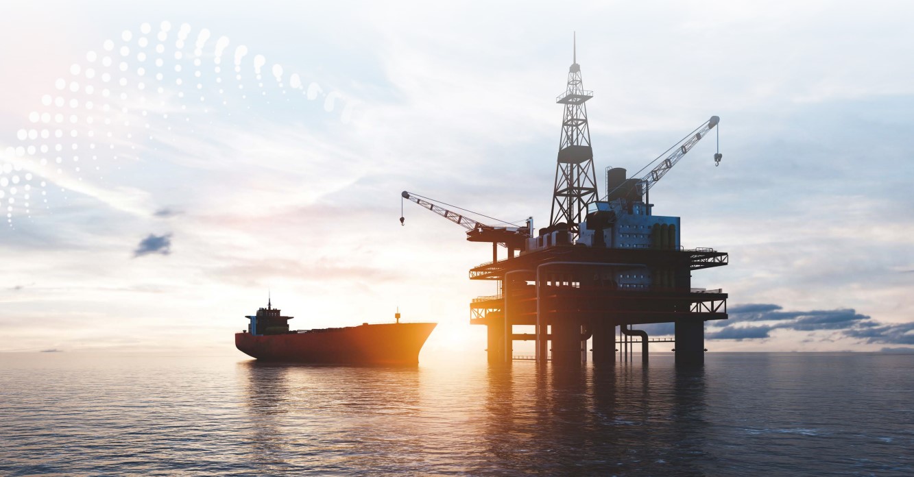 An offshore rig and a vessel at sunset