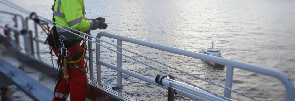 An engineer wearing safety harness onboard a vessel