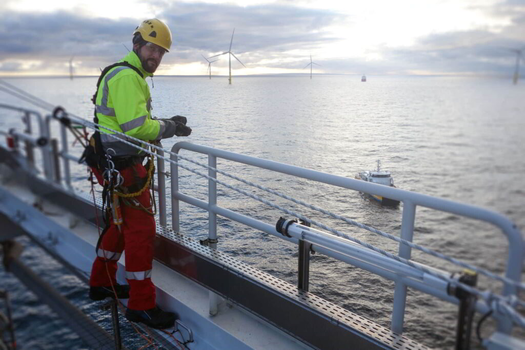 An engineer wearing safety harness onboard a vessel