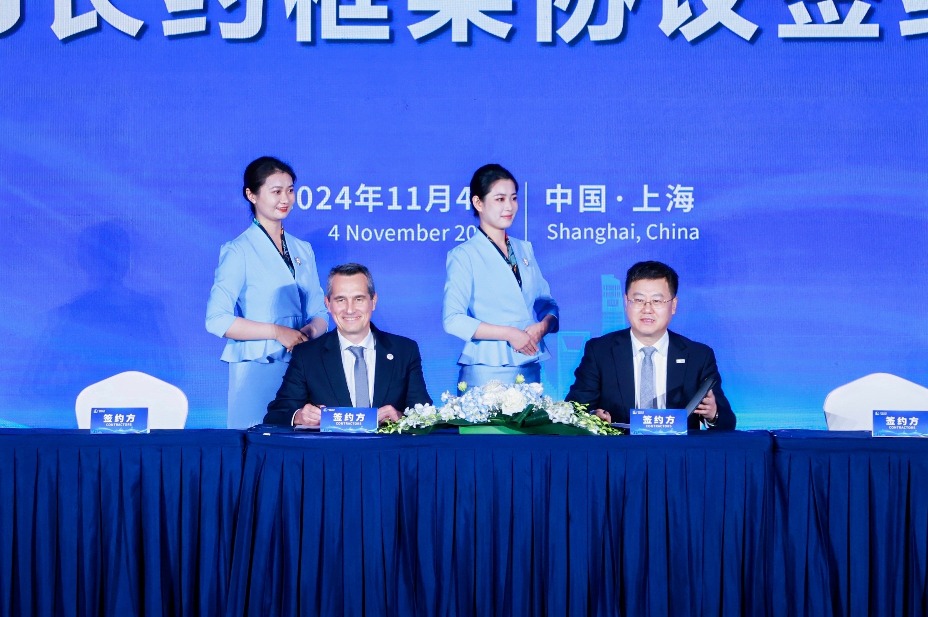 Two men sitting at a desk with two women standing behind them