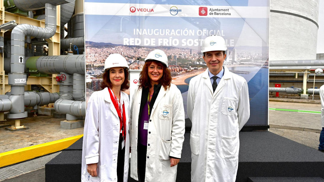 Two women and one man standing in front of a sign