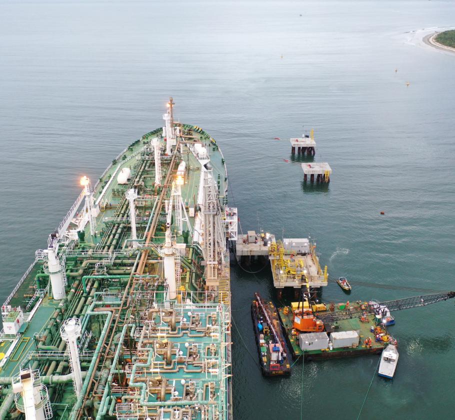 Aerial view of a large vessel at dock with smaller vessels next to it