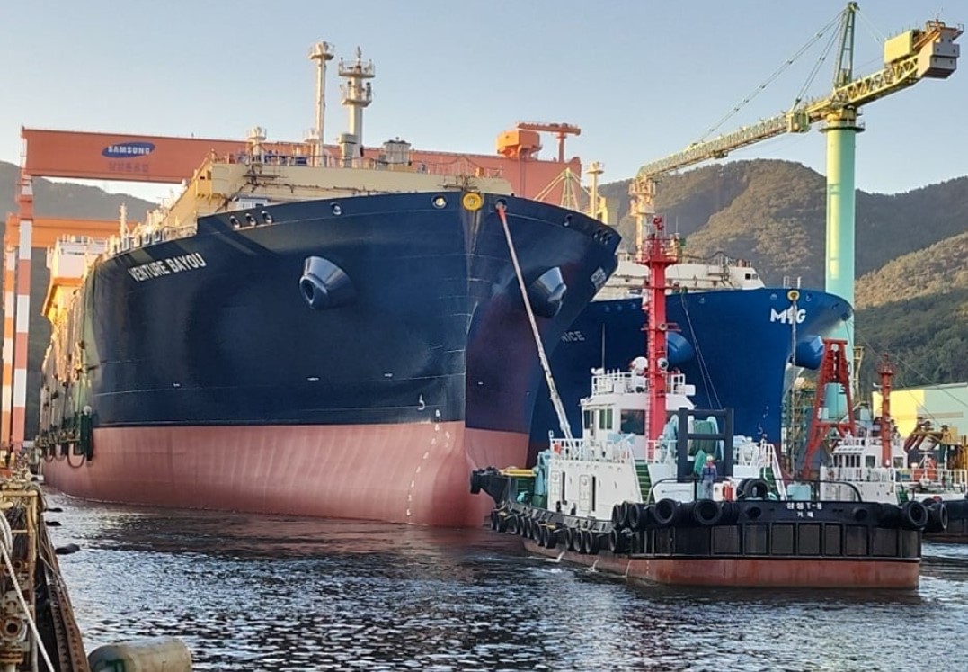 A large vessel being tugged by a smaller one