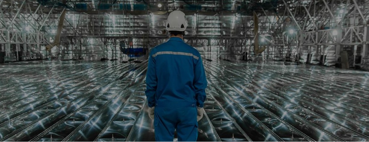 Man seen from behind standing inside a metal tank