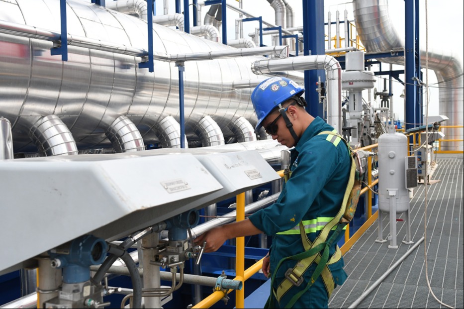 A worker inspecting a pipe