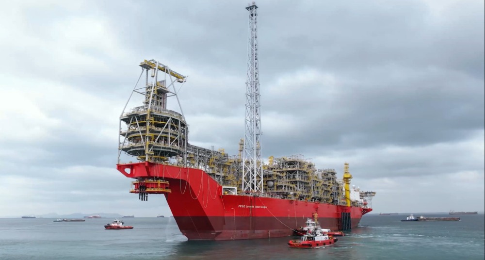 A large vessel at sea surrounded by several smaller ones