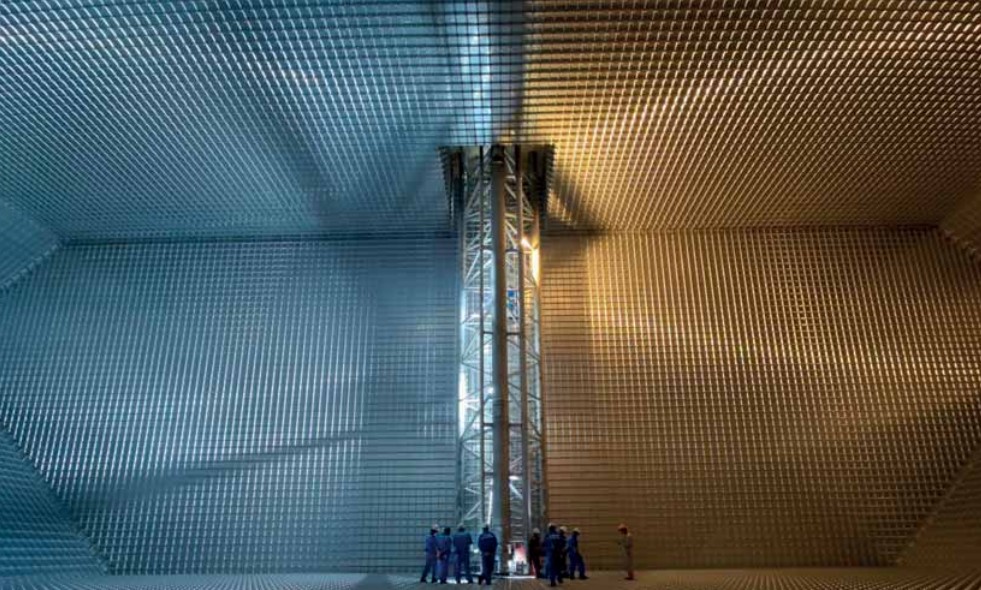 Several men standing inside of a large metal tank