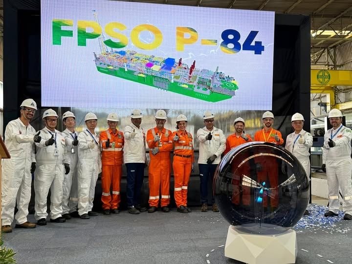 Several people standing in line at a steel-cutting ceremony