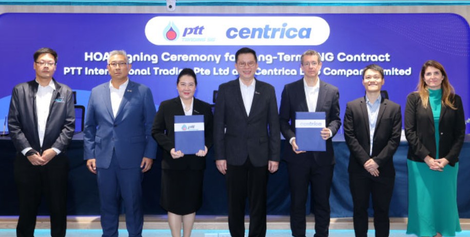 Several people holding documents at an agreement signing ceremony