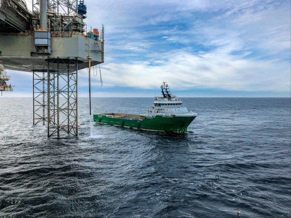 A vessel next to an offshore platform